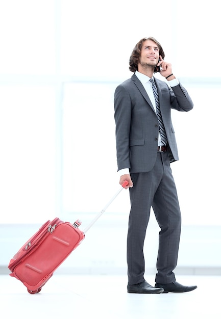 携帯電話で話している荷物を持つビジネスマン