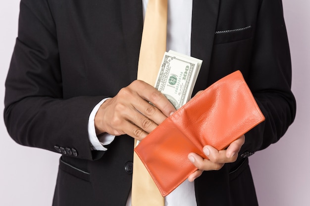 Businessman with money and orange wallet in studio . Business concept