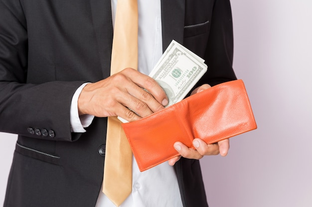 Businessman with money and orange wallet in studio 