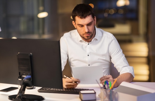 businessman with papers working at night office
