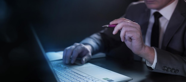 Businessman with a pen in his hand at the computer