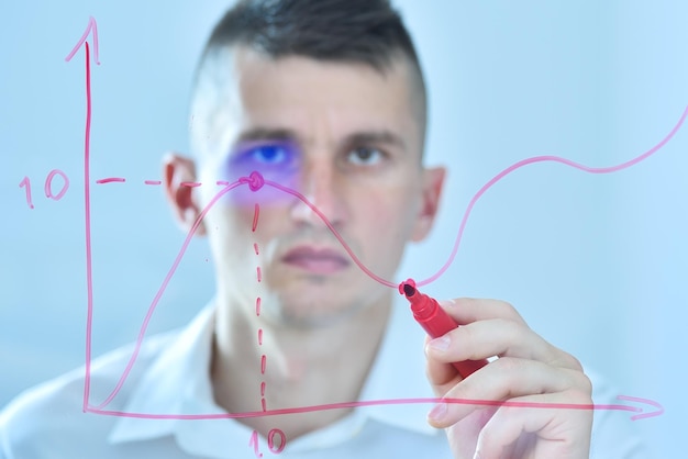 Photo businessman with red pen drawing stock chart on glass screen analyzing at data and checking business chart investment and financial concept