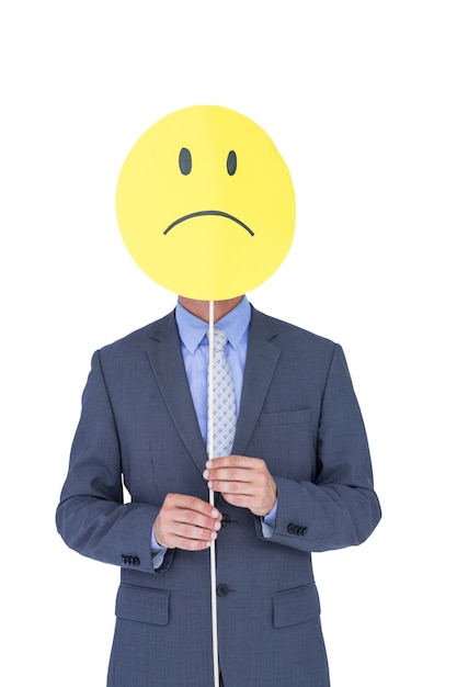  Businessman with sad smiley faced balloon at office desk