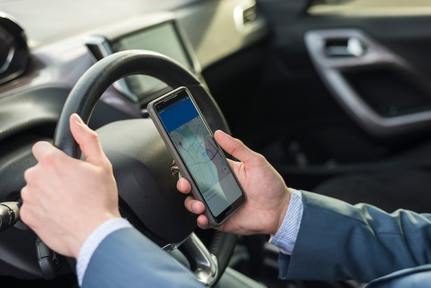 Photo businessman with smartphone in car