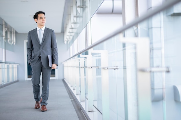 Foto uomo d'affari con lo smartphone che cammina contro la strada sfocata sullo sfondo dell'edificio, fashion business.