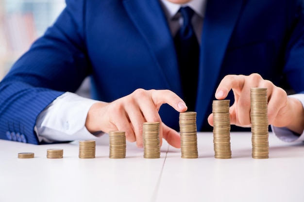 Businessman with stacks of coins in the office