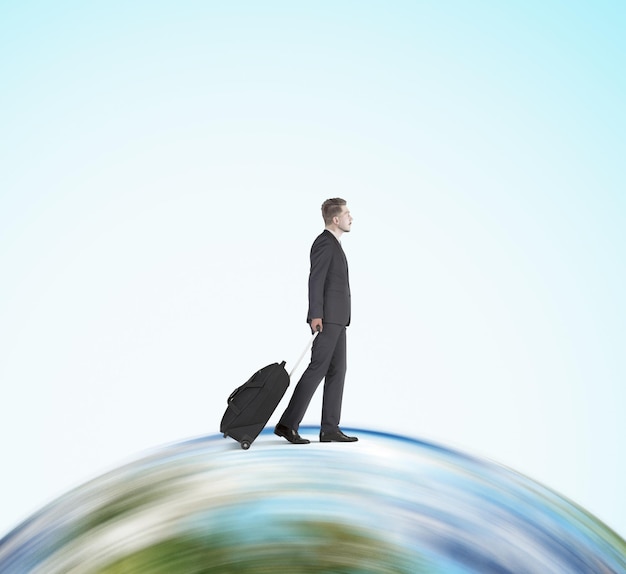 Businessman with suitcase going on the globe