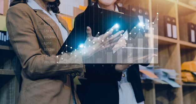 Businessman with a tablet in his hand and touching on the
screen that shows a business graph the concept of starting a new
business that goes better