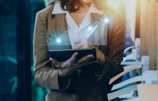 Businessman with a tablet in his hand and touching on the\
screen that shows a business graph the concept of starting a new\
business that goes better