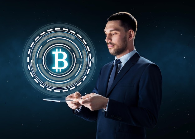 businessman with tablet pc and bitcoin hologram