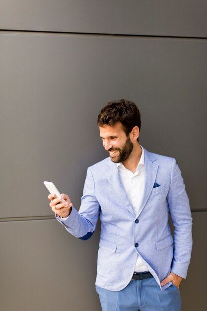 Businessman with a telephone by the black wall