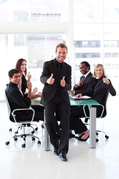 Businessman with thumbs up in a meeting