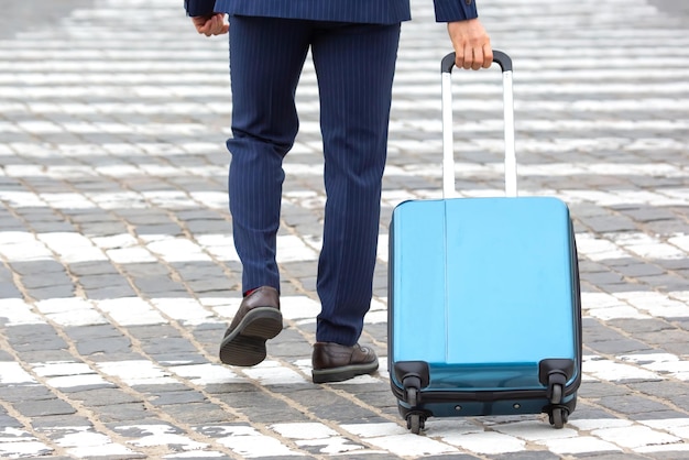 Photo businessman with travel suitcase crossed signposted crossing of city street