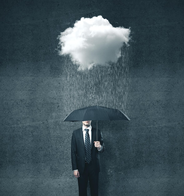 Businessman with umbrella and cloud