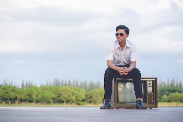 Businessman with vintage tv in nature.