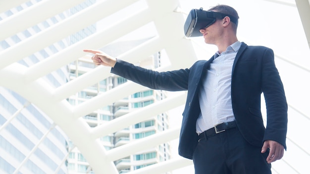 businessman with vr glass for smartphone stand at outdoor