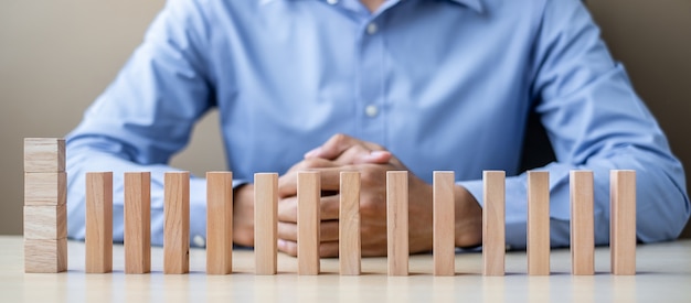 Businessman with wooden Blocks or Dominoes. Business