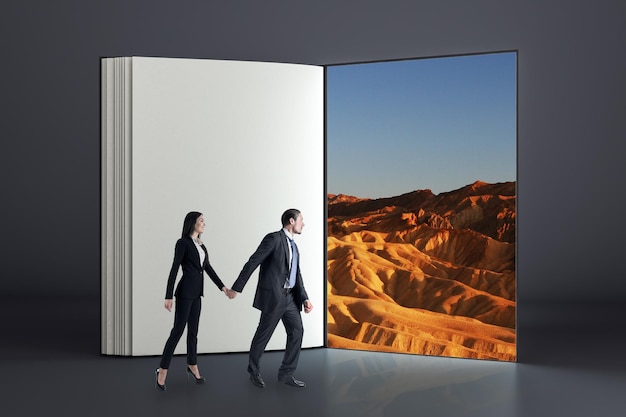 Businessman and woman entering abstract open book into desert space Teamwork and success concept