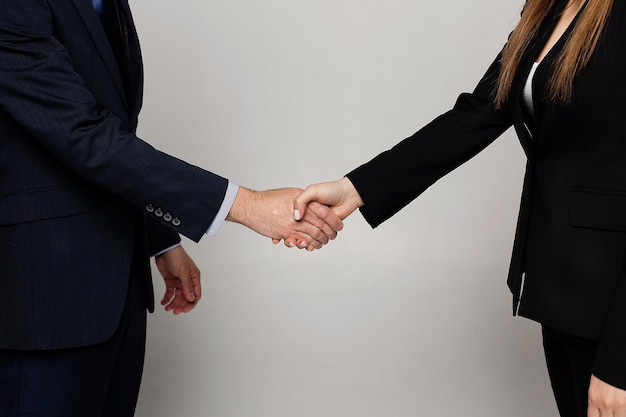 Businessman and woman shake hands as hello in office closeup Friend welcome introduction greet or thanks gesture product advertisement partnership approval arm strike a bargain on deal concept