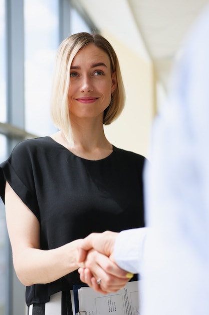 Businessman and woman shake hands as hello