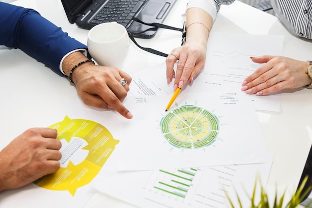 Businessman and woman work with infographics documents on office white table with laptop