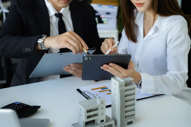 Businessman working as a team discussing data working and tablet laptop at desk in office