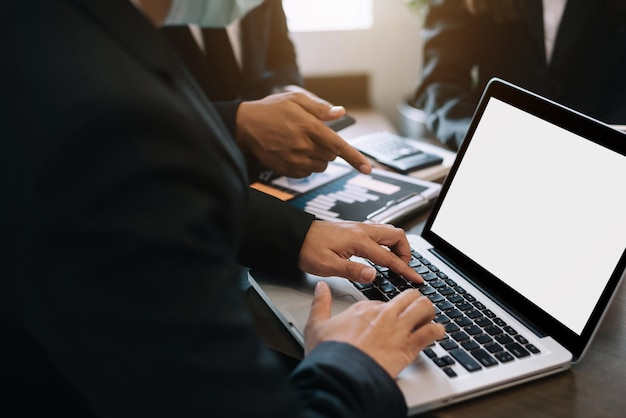 Businessman working as a team start meeting the new marketing project plan By business people using laptop and tablets and graph documents Calculate the amount of money for the project