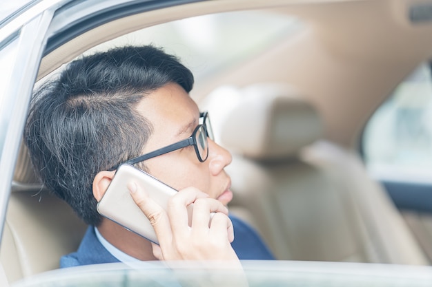 車の後部座席で働くビジネスマン