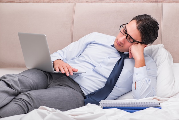 Businessman working in the bed at home