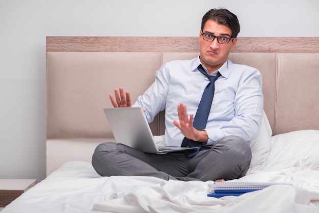 Businessman working in the bed at home