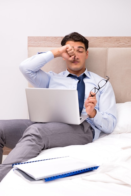 Businessman working in the bed at home