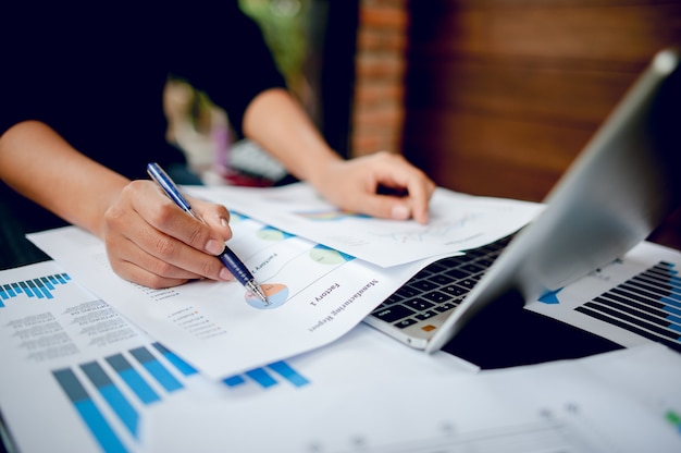 Businessman working at a computer office And graphs on his desk. Business ideas and space for copy.