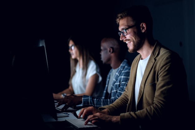 Businessman working on the computer in the office at nightthe concept of overtime