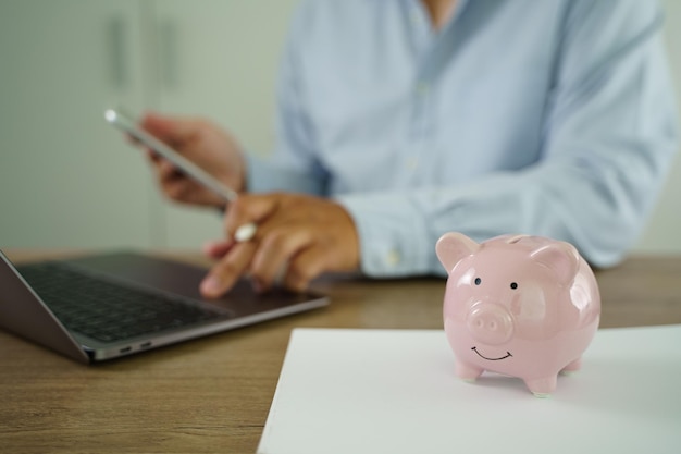 Businessman working on desk office finance accounting saving money Piggy bank with business