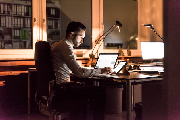 Businessman working at desk in office at night