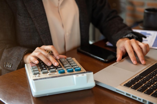 Businessman working on desk office with using a calculator to calculate