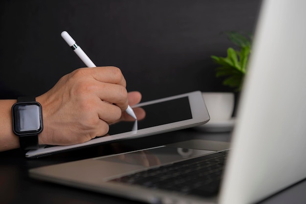 Businessman working on digital tablet and laptop computer on glass table