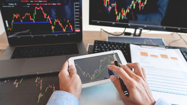 Businessman working on forex trading with laptop and tablet