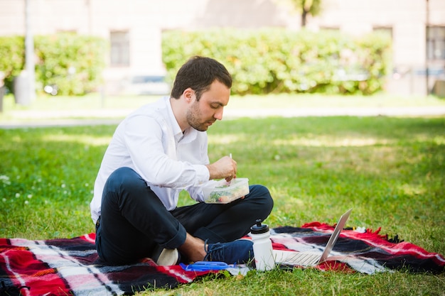 Businessman working in the garden and eating lunch