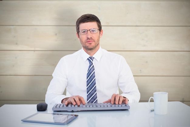 Businessman working at his desk against bleached wooden planks background