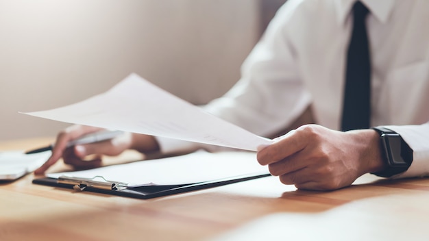 Businessman working at his office with documents and check the accuracy of information.