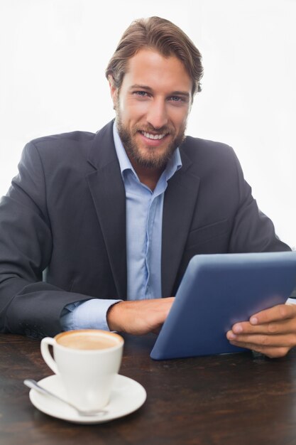 Photo businessman working on his tablet having coffee