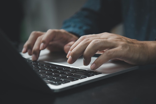 Businessman working laptop computer hand typing keyboard computer office technology communication internet on desk