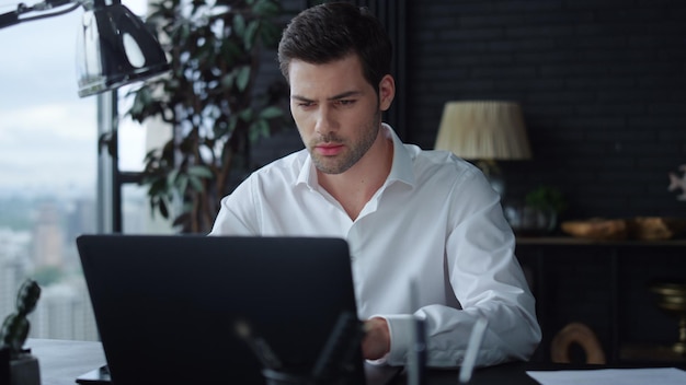 Businessman working on laptop in office Manager reading good news on computer