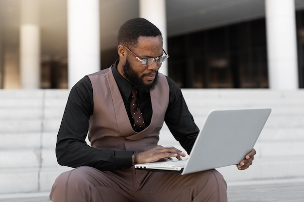 Businessman working on laptop outdoors