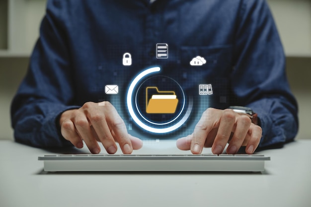 Businessman working on laptop with electronic document folder and files icon