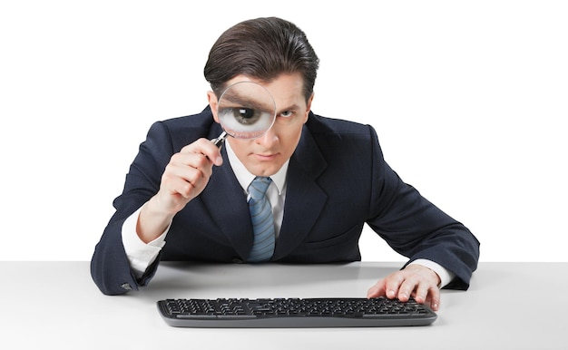 Businessman working and looking in magnifying glass