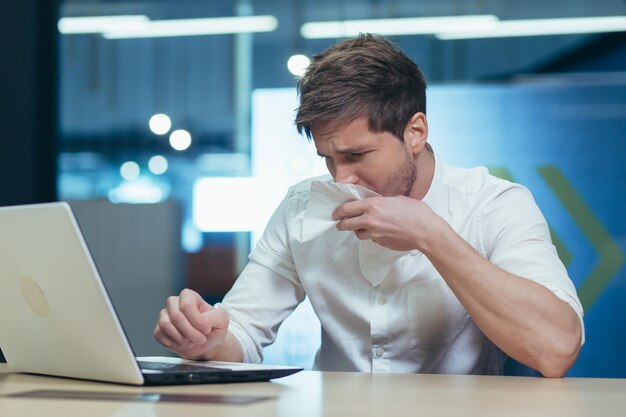 Businessman working in the office has a seasonal allergy sneezes