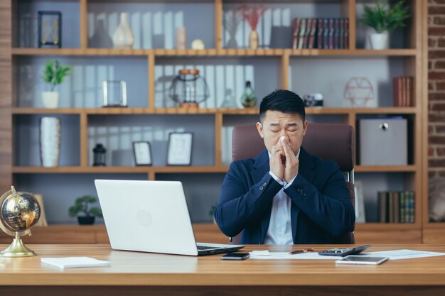 Businessman working in the office sick Asian has a cold and flu runny nose from allergies