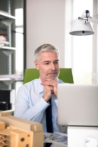 Businessman working in office, using laptop